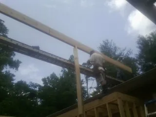 Carpenter setting a ridge beam over a new addition frame — Ice Dam Removal by Roofing Brothers in West Stockbridge