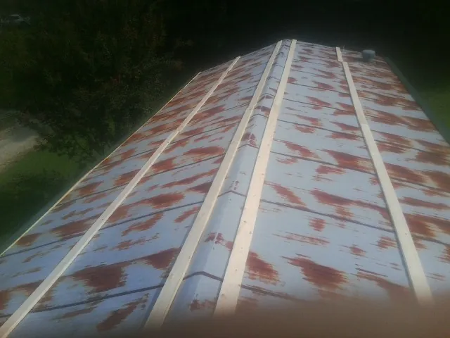 Rusted metal roof panels with new wood purlins before replacement — Storm Damage Roof Repair in West Stockbridge by Roofing Brothers