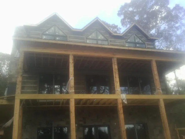 Dormers and porch framing on a large log home under construction — Roof Coating work by our crew in West Stockbridge