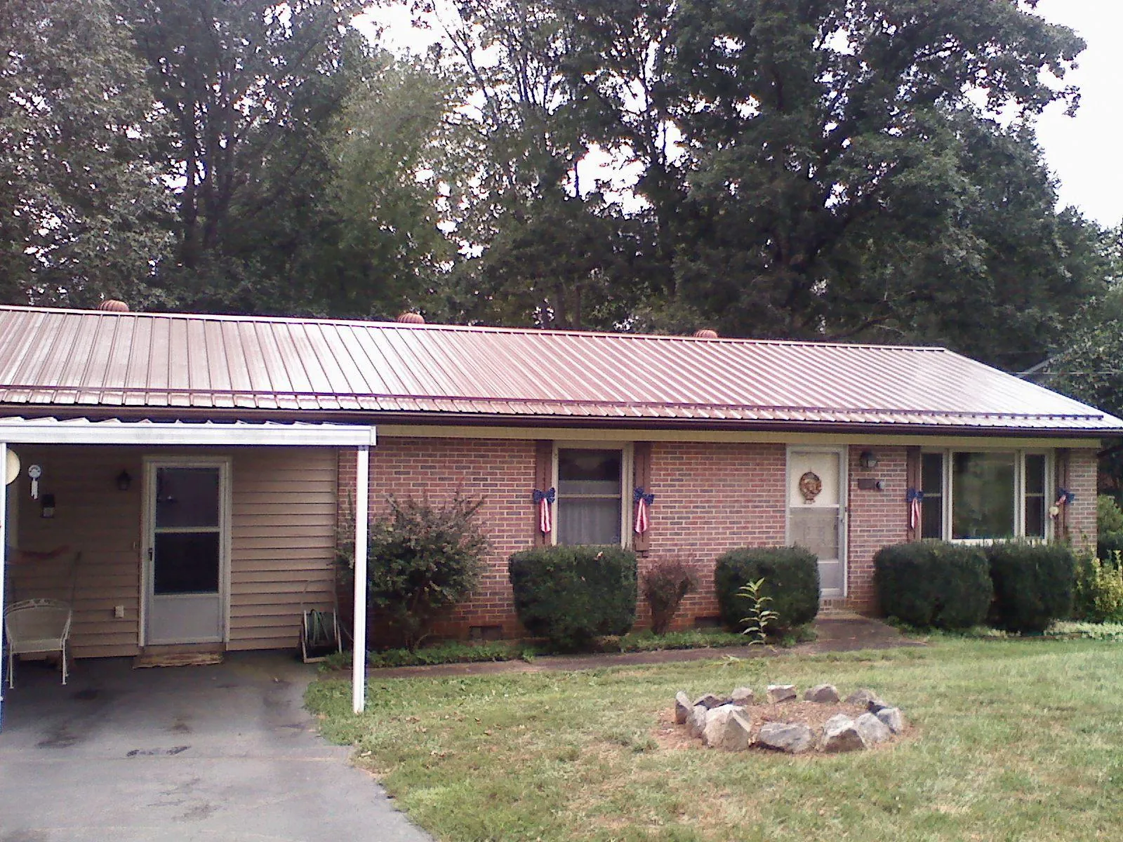 Bronze metal roof and carport on a brick ranch home — Roof Repair work by our crew in West Stockbridge